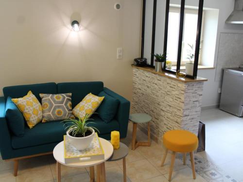 un salon avec un canapé bleu et une table dans l'établissement Gîte cosy 4 pers., terrasse, proche activités nature, WiFi, parking à Cherveix-Cubas - FR-1-616-392, à Cherveix-Cubas