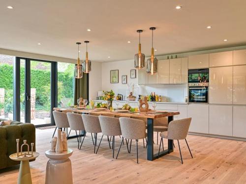 une cuisine et une salle à manger avec une grande table et des chaises en bois dans l'établissement Villa d'Architecte à Marcq-en-Barœul avec Jeux, WiFi, Clim et Parking - FR-1-510-226, à Marcq-en-Barœul