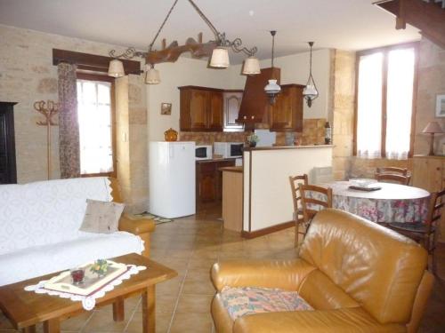 un salon et une cuisine avec un canapé et une table dans l'établissement Gîte confortable proche Sarlat, jardin, ping-pong, parking - FR-1-616-403, à Proissans