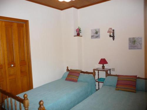 - une chambre avec 2 lits et une porte en bois dans l'établissement Gîte confortable proche Sarlat, jardin, ping-pong, parking - FR-1-616-403, à Proissans