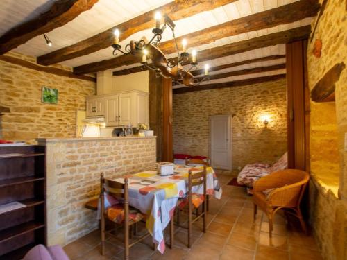 une cuisine avec une table et des chaises dans une pièce dans l'établissement Maison rustique avec jardin et équipements pour enfants, proche Sarlat - FR-1-616-394, à Marcillac-Saint-Quentin