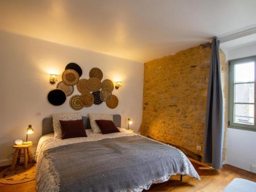 a bedroom with a large bed with a stone wall at Maison climatisée avec jardin au cœur de Sarlat - FR-1-616-399 in Sarlat-la-Canéda