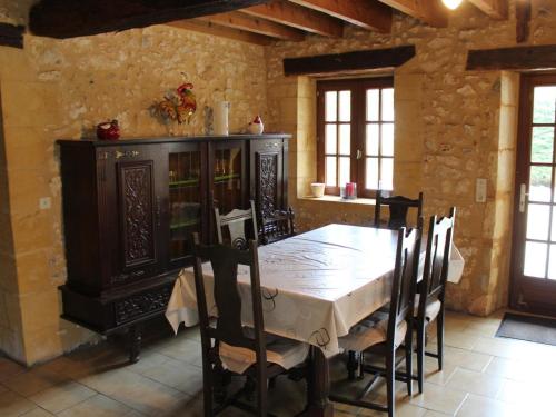 d'une salle à manger avec une table et une armoire en bois. dans l'établissement Gîte périgourdin avec piscine partagée, cheminée et animaux admis près de Bergerac - FR-1-616-416, à Naussannes