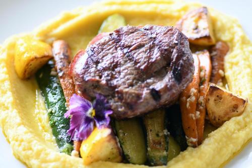 a plate of food with a steak and vegetables at Grandpas Hotel & Restaurante in Cartago