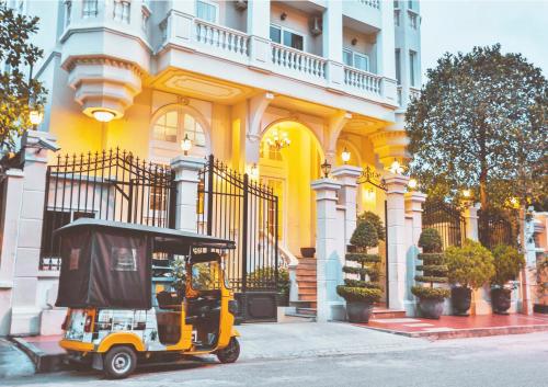 einem gelben Golfwagen, der vor einem Gebäude parkt in der Unterkunft Palace Gate Hotel & Residence By EHM in Phnom Penh