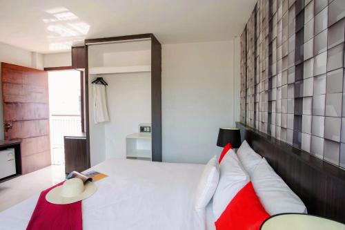 a bedroom with a white bed with red and white pillows at The Wings Boutique Hotels Krabi Ko Lanta in Ko Lanta