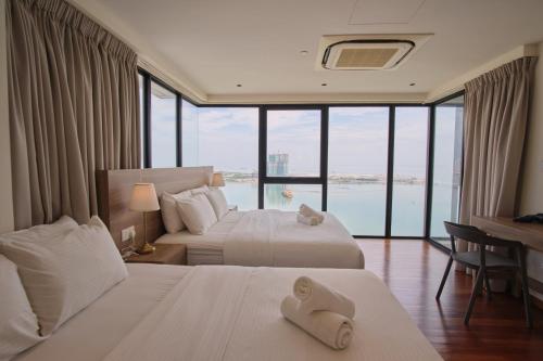 une chambre d'hôtel avec deux lits et un bureau dans l'établissement Sunrise Gurney, à George Town