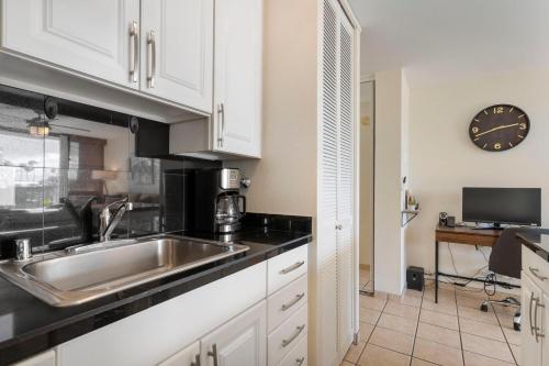 a kitchen with a sink and a clock on the wall at Cute Ocean View Condo, walk to beach LSV03 in Kihei