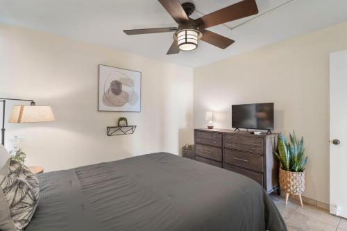 a bedroom with a bed and a flat screen tv at Cute Ocean View Condo, walk to beach LSV03 in Kihei
