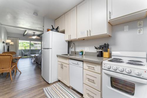a kitchen with white cabinets and a white refrigerator at Cute Studio across the Beach, pool, hot tub, wifi LSV04 in Kihei