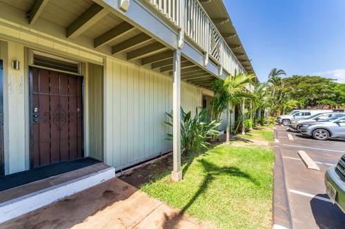 a building with a brown door next to a parking lot at Cute Studio across the Beach, pool, hot tub, wifi LSV04 in Kihei