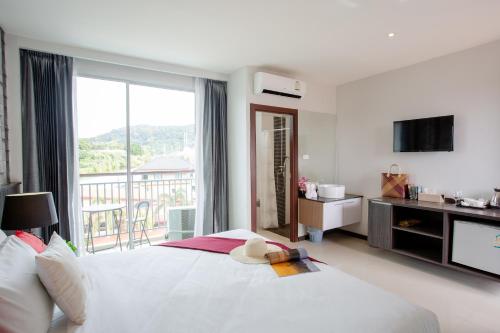 a bedroom with a large white bed and a balcony at The Wings Boutique Hotels Krabi Ko Lanta in Ko Lanta