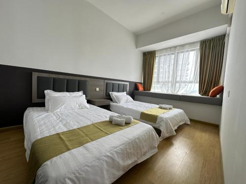 a hotel room with two beds and a window at Astonishing Ocean View 3 Bedroom Apartment in Johor Bahru