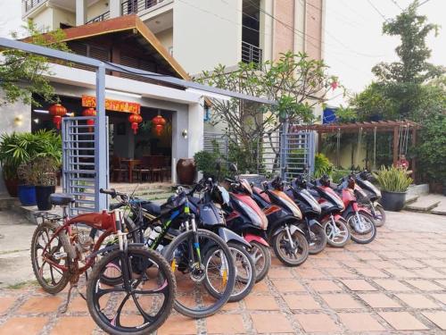 a row of motorcycles parked in front of a building at Neakru Guesthouse and Restaurant in Kampot