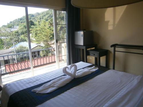 a bedroom with a bed with a large window at Infinity Boutique Hotel Kata Beach in Ban Kata