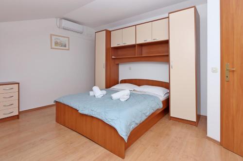a bedroom with a bed with two towels on it at Seaside house for families with children Barbat, Rab - 22294 in Rab