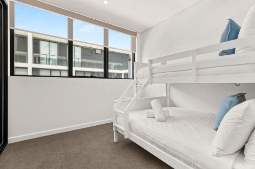 a bedroom with two bunk beds and a window at Ocean Bliss by Experience Jervis Bay in Huskisson