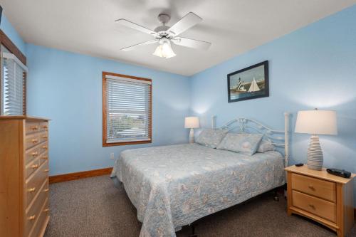 une chambre avec un lit et un ventilateur de plafond dans l'établissement WH582 Beachnuts Too, à Corolla