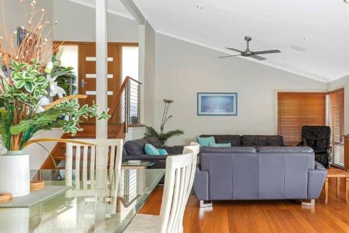 a living room with a couch and a table at Tranquility with Spa & Jetty in Woy Woy