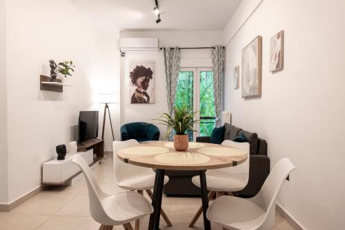 a dining room and living room with a table and chairs at Afroditi in Athens