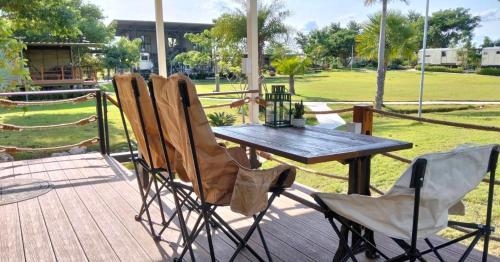 a wooden table and chairs sitting on a deck at Nex Station Kanchanaburi in Kanchanaburi