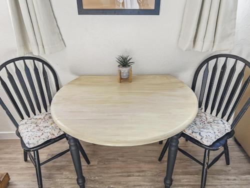 a wooden table with two chairs and a plant on it at Quaint Monument Retreat studio in Grand Junction
