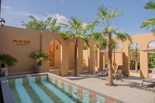 a villa with a swimming pool and palm trees at The Wood Terrace in Ban Chin Tham Mai