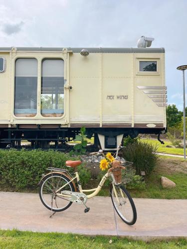 a bike is parked in front of a train at Nex Station Kanchanaburi in Kanchanaburi