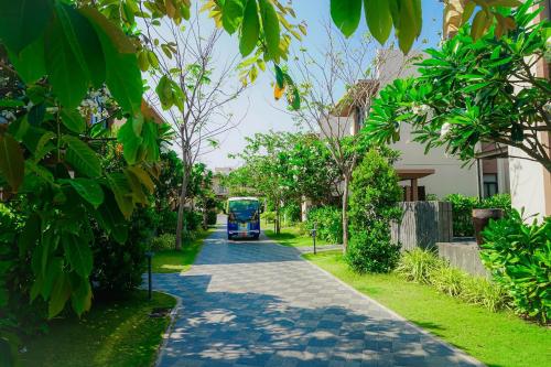 a blue bus is driving down a street at Hese Pool Villas & Resort Cam Ranh in Cam Ranh