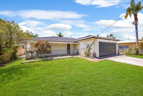 a house with a green lawn in front of it at Pet Friendly home in Maroochydore in Maroochydore