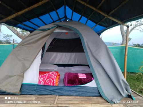 a tent with the door open with two beds at Fesengbor eco camp in Kāziranga