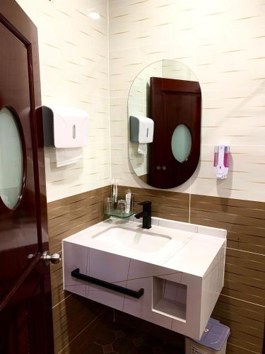 a bathroom with a white sink and a mirror at Motel Mỹ Vân in Can Tho