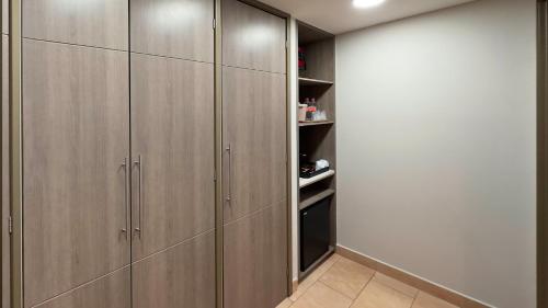 a walk in closet with wooden cabinets at Holiday Inn Express Mérida by IHG in Mérida