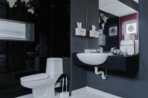 um banheiro com um vaso sanitário branco e uma pia em Georgetown Karpal Singh Getaway 4BR 娱乐设施洋房乔治市 em Jelutong