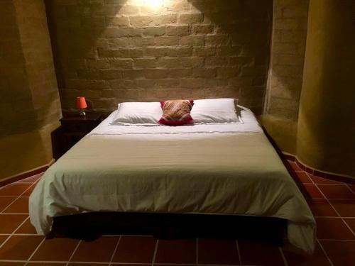 a bed with a pillow on it in a room at Habitación Ancestral Sol Muisca in Villa de Leyva