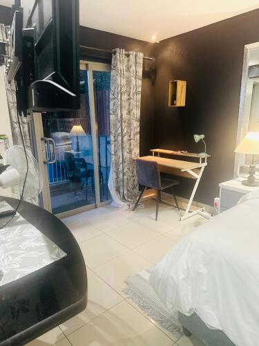 a bedroom with a bed and a table and a desk at Tranquil Pool View in Cape Town