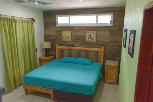 a bedroom with a bed with blue sheets and a window at Gran Ubicación Terraza Privada Jacuzzi in Cozumel