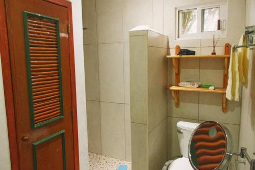 a small bathroom with a toilet and a window at Gran Ubicación Terraza Privada Jacuzzi in Cozumel