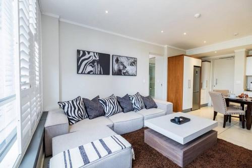 a living room with a couch and a table at Masingita Towers - Luxurious Apartment Condo in Sandton in Johannesburg