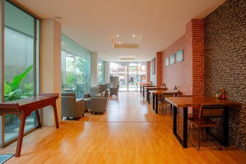 een restaurant met tafels en stoelen en een bakstenen muur bij The Wings Boutique Hotels Krabi Ko Lanta in Koh Lanta