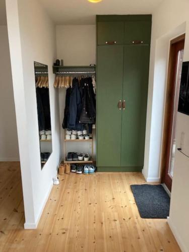 a hallway with a green closet with shoes in it at Moderne og centralt rækkehus i Herning in Herning