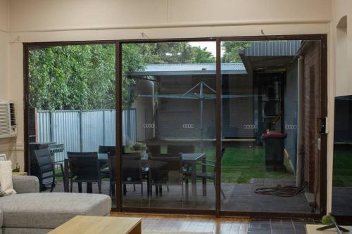 a living room with sliding glass doors and a table at Central Delight in Dubbo