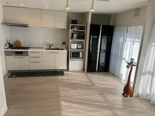 a kitchen with white cabinets and a black refrigerator at Ne O in Tokyo