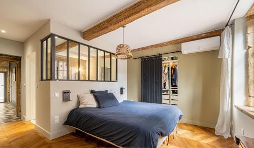 une chambre avec un lit avec une couette bleue dans l'établissement Maison de charme - 15 min de Lyon, à Saint-Romain-au-Mont-dʼOr