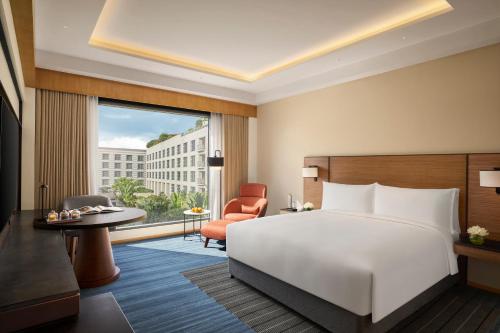a bedroom with a bed and a desk and a chair at Grand Hyatt Mumbai Hotel and Residences in Mumbai