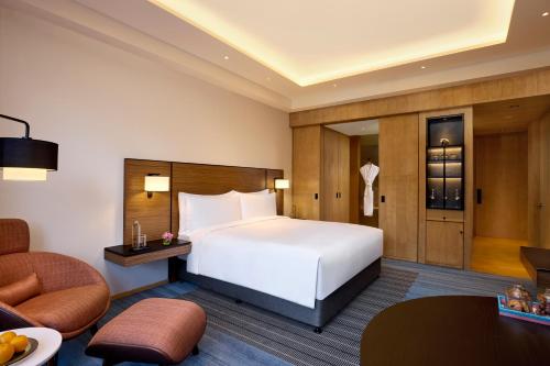 a hotel room with a bed and a chair at Grand Hyatt Mumbai Hotel and Residences in Mumbai