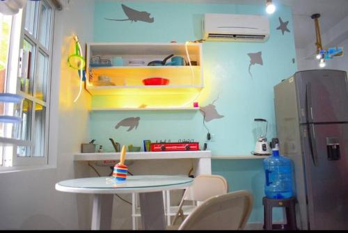 eine kleine Küche mit Tisch und Kühlschrank in der Unterkunft Little Oasis Cozumel in Cozumel