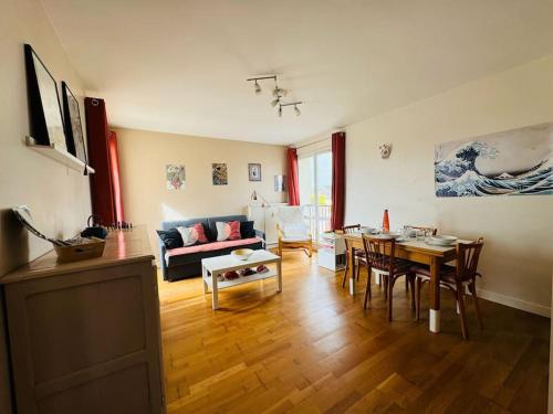 un salon avec un canapé et une table dans l'établissement Appartement résidence calme proche centre-ville, à Caen