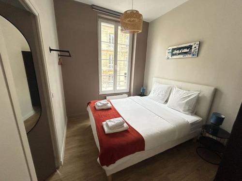 une chambre avec un lit avec deux serviettes dessus dans l'établissement Bel appartement Hyper-centre, à Caen