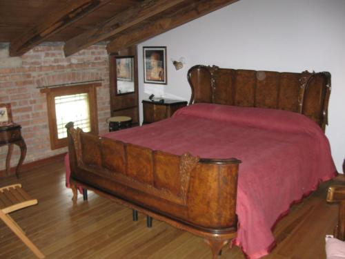 a bedroom with a large wooden bed with a red blanket at Agriturismo Il Casotto in Maida
